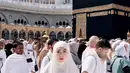 Celine Evangelista juga menjalankan umrah saat bulan Ramadan. Berfoto di depan Ka’bah, ia tampil mengenakan khimar putih dipadukan abaya warna senada. [@celine_evangelista]