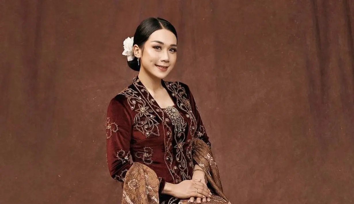 Puput tampil menawan mengenakan kebaya velvet maroon berpayet yang dipadukan selendang dan bawahan kain batik. [@victoria_makeupatelier]