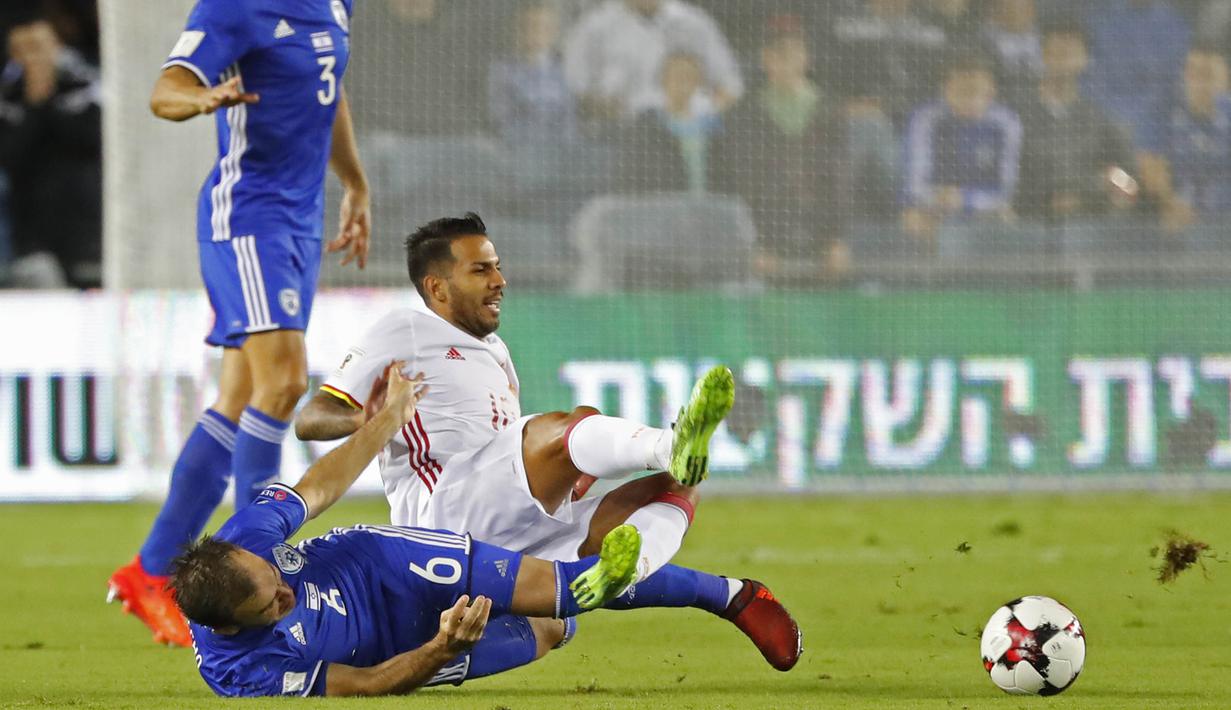 Gelandang Spanyol, Jonathan Viera, dijatuhkan gelandang Israel, Bibras Natcho, pada laga kualifikasi Piala Dunia 2018 di Stadion Teddy, Yerusalem,Senin (9/10/2017). Israel kalah 0-1 dari Spanyol. (AFP/Jack Guez)