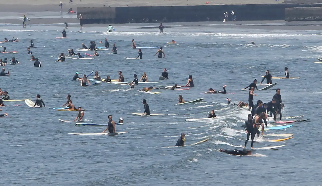 Peselancar menunggu ombak dari pantai Katase-kaigan di Fujisawa, prefektur Kanagawa, dekat Tokyo, Senin (8/6/2020). Jepang mengangkat keadaan darurat coronavirus-nya, mengakhiri pembatasan secara nasional ketika bisnis mulai dibuka kembali. (AP Photo/Koji Sasahara)