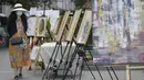 Seorang wanita mengamati karya seni yang dipajang di area terbuka dalam pameran Art Downtown, Vancouver, British Columbia, Kanada, 4 September 2020. Art Downtown merupakan proyek yang memungkinkan seniman dan publik saling terhubung dan menginspirasi serta berbagi kreativitas. (Xinhua/Liang Sen)