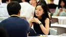 Seorang wanita berbincang dengan seorang pria saat acara perjodohan di Hangzhou, Provinsi Zhejiang, China (14/5). Acara ini menarik minat ribuan pria dan wanita. (AFP Photo/Str/China Out)