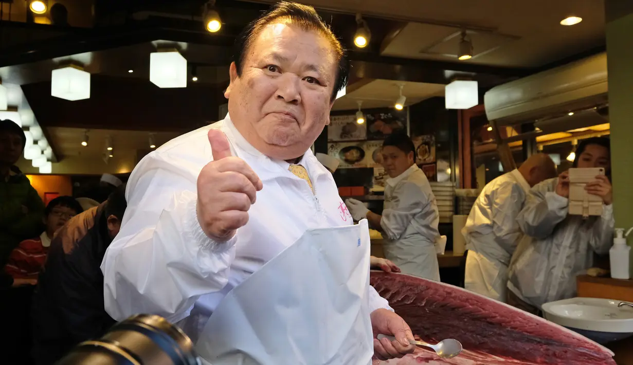Pengusaha restoran sushi Jepang, Kiyoshi Kimura mencicipi tuna sirip biru seberat 278 kg di restorannya, Tokyo, Sabtu (5/1). Tuna raksasa itu dibeli dalam lelang perdana 2019 dengan harga USD3,1 juta atau setara Rp43,4 miliar. (Kazuhiro NOGI/AFP)