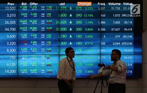 Pekerja bercengkerama di depan layar pergerakan Indeks Harga Saham Gabungan (IHSG) di BEI, Jakarta, Rabu (16/5). IHSG ditutup naik 3,34 poin atau 0,05 persen ke 5.841,46. (Liputan6.com/Angga Yuniar)