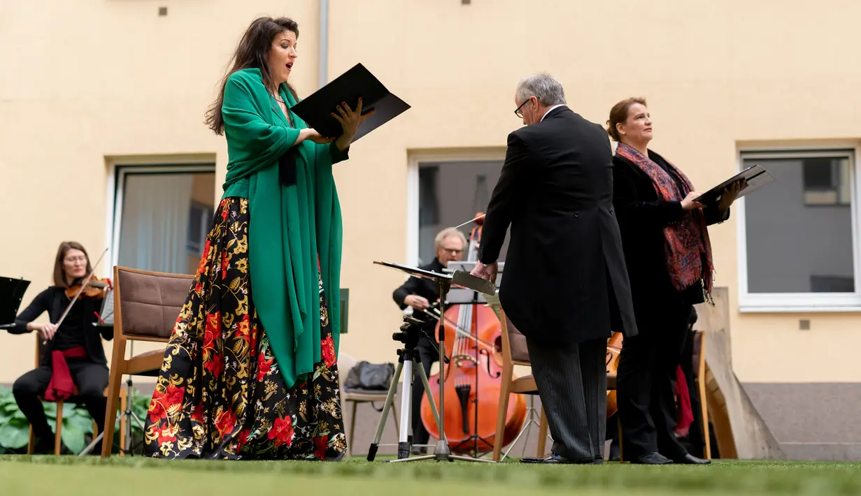 Penyanyi Monika Medek dan Dagmar Dekanovsky serta orkestra Camerata Carnutum menggelar konser jendela (Fensterkonzert) di halaman Zeitgeist Hotel di Wina, Sabtu (30/5/2020). "Konser jendela" diadakan untuk merayakan pembukaan kembali hotel di Austria di tengah pandemi COVID-19. (JOE KLAMAR/AFP)