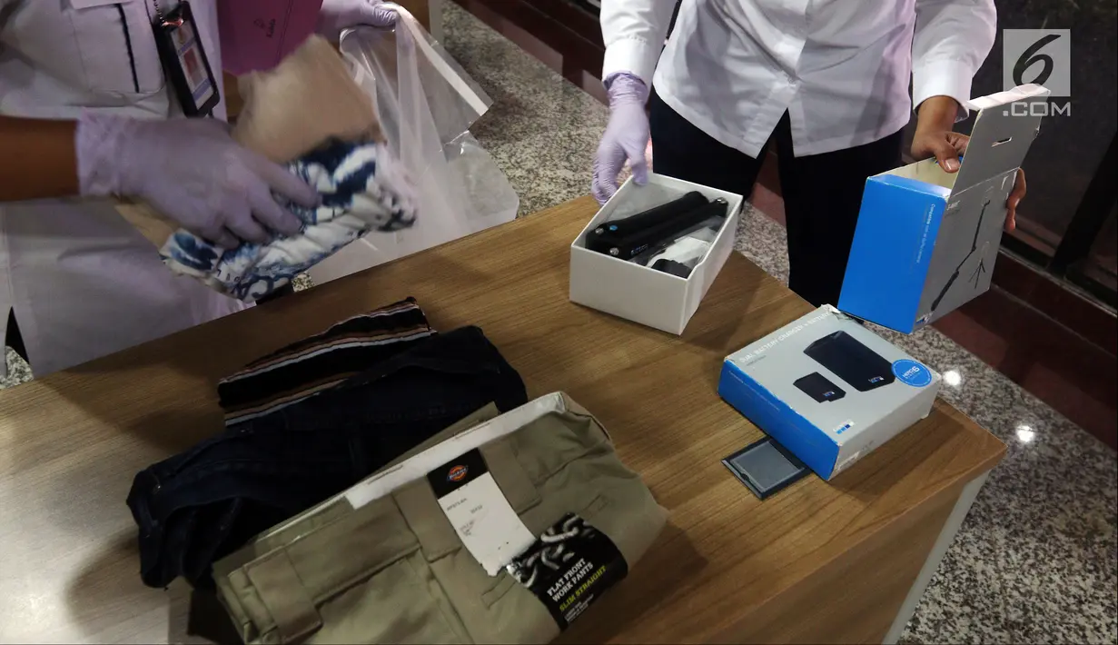 Petugas merapikan barang bukti saat rilis kasus pencurian data nasabah kartu kredit WN Australia di Direktorat Tindak Pidana Siber Bareskrim Polri, Jakarta, Selasa (28/8). Polisi mengamankan dua tersangka terkait kasus tersebut. (Liputan6.com/JohanTallo)