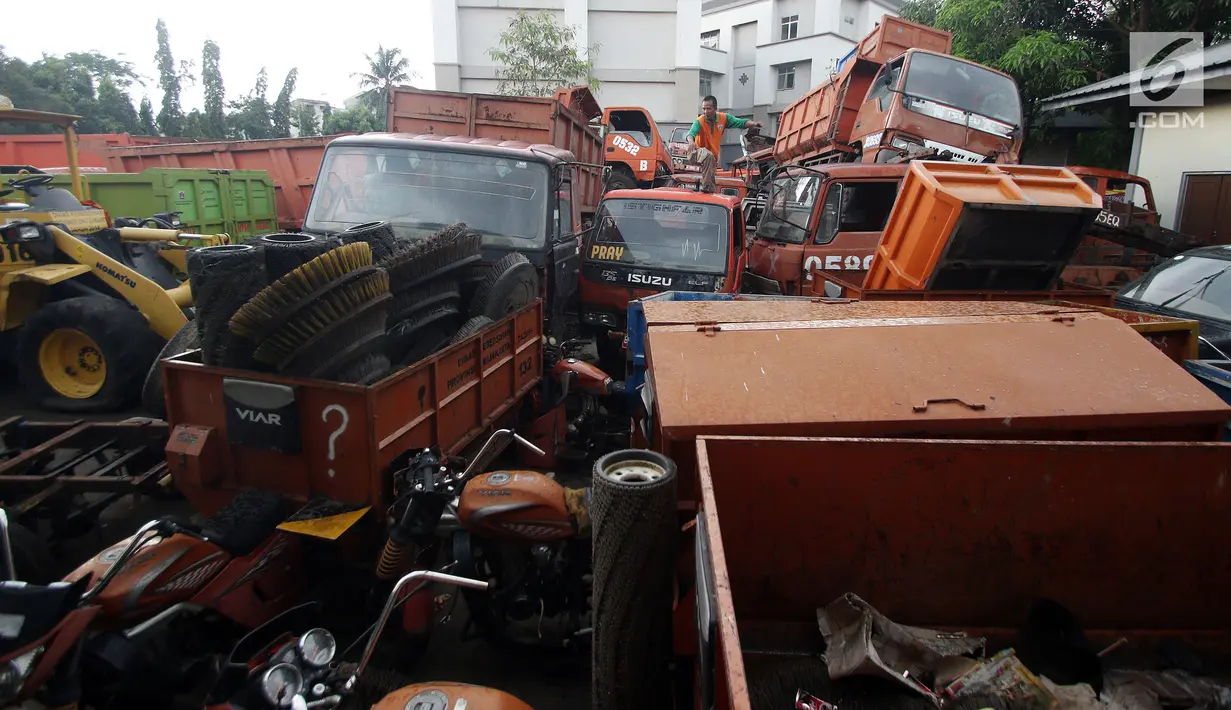 Petugas melakukan pengecekan bangkai armada truk sampah di Kantor Suku Dinas Lingkungan Hidup, Jakarta Barat, Selasa (27/3). Truk-truk tersebut menunggu antrean lelang yang sudah dilaporkan sejak Desember 2017. (Liputan6.com/JohanTallo)