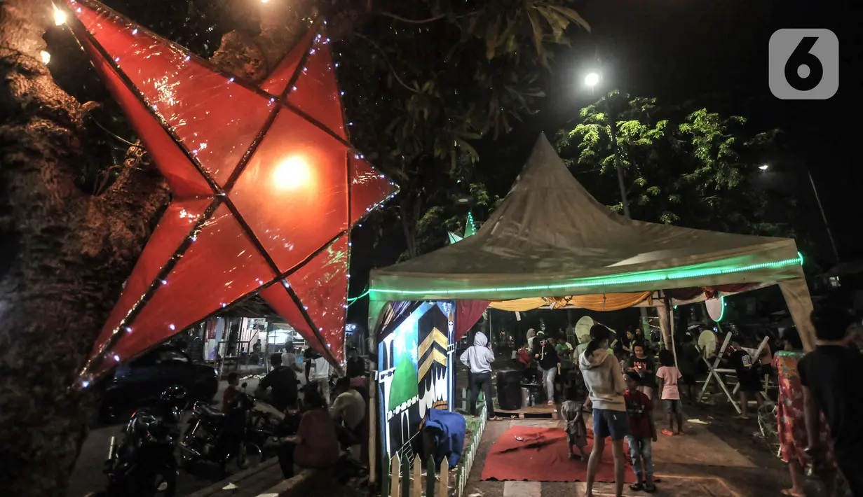 Warga menikmati suasana takbiran Idul Fitri di kawasan Manggarai, Jakarta, Rabu (13/5/2021). Tradisi merayakan malam takbiran dengan memainkan bedug dan membuat hiasan bernuansa Islam masih terlihat di pinggiran Ibu Kota meski berada di tengah pandemi Covid-19. (merdeka.com/Iqbal S. Nugroho)