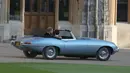 Pangeran Harry dan istrinya Meghan Markle meninggalkan Kastil Windsor (19/5). Jaguar Classic E-Type Concept Zero tahun 1968 ini telah direstorasi dan tak lagi menggunakan mesin konvensional tapi motor listrik. (AFP Photo/Pool/Steve Parsons)