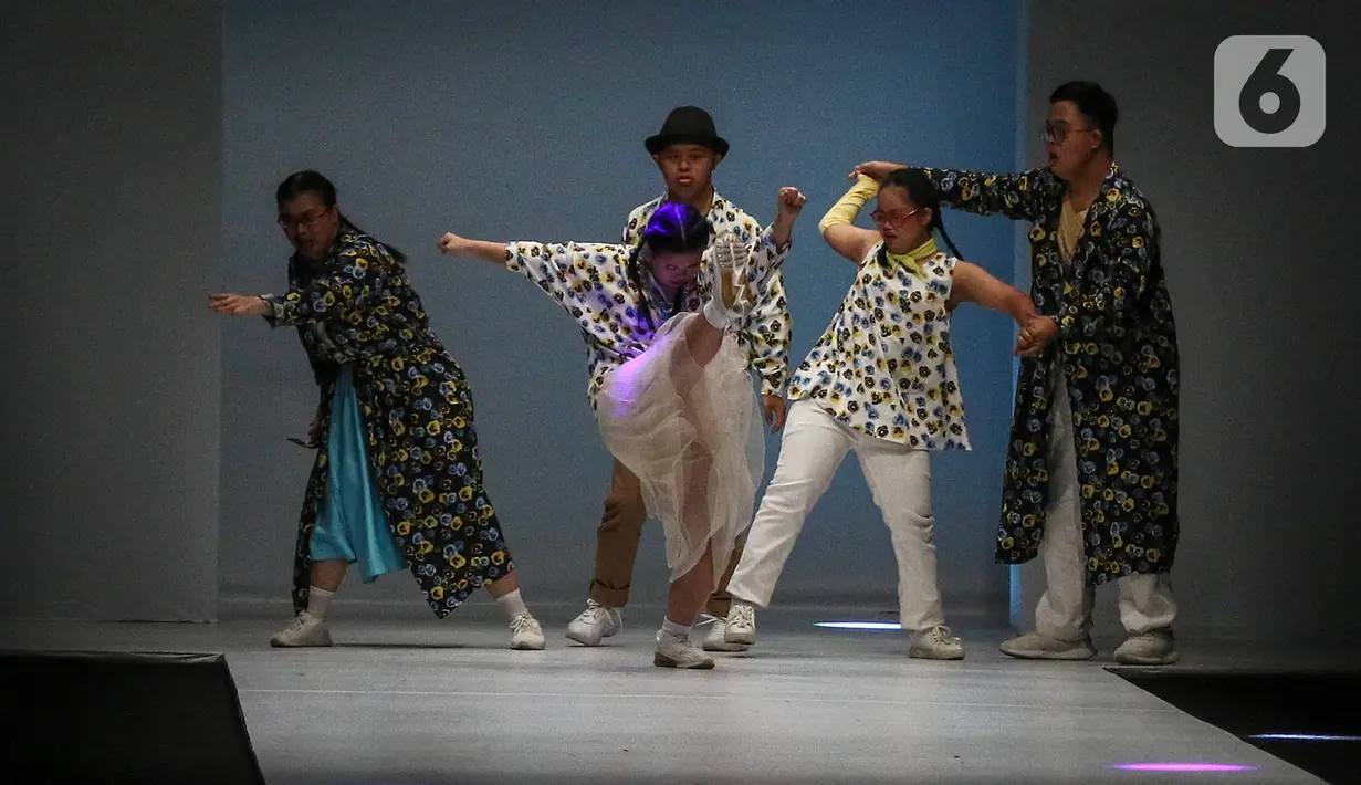 Model disabilitas mengenakan busana rancangan kolaborasi Cotton Ink x Intoart yang digawangi British Council pada Jakarta Fashion Week 2020 di Senayan, Kamis (24/10/2019). Kolaborasi ini menampilkan model disabilitas yang terdiri dari down syndrome, tuna daksa dan tuli. (Liputan.com/Johan Tallo)