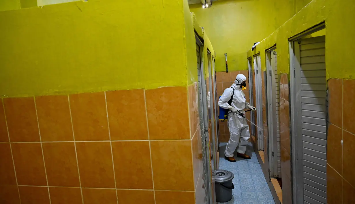 Seorang anggota Badan Penanggulangan Bencana Daerah (BPBD) menyemprotkan disinfektan di toilet sebuah Sekolah Menengah Pertama (SMP) dalam rangka program mitigasi pencegahan penyebaran flu burung di Banda Aceh pada Jumat 31 Oktober 2025. Sterilisasi difokuskan pada area asrama baik putri maupun putra. (Chaideer MAHYUDDIN/AFP)