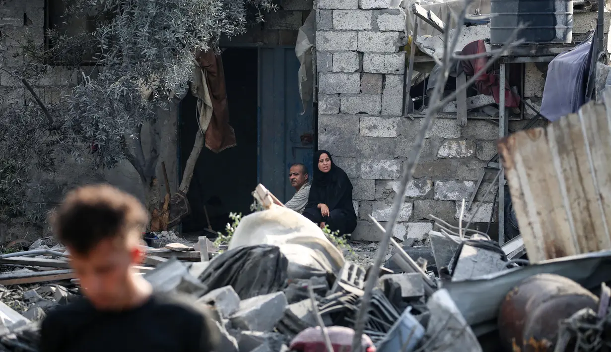 Warga Palestina duduk di antara reruntuhan rumah setelah serangan Israel semalam yang menghantam Nuseirat, Jalur Gaza tengah pada 13 Juli 2025. (Eyad BABA/AFP)