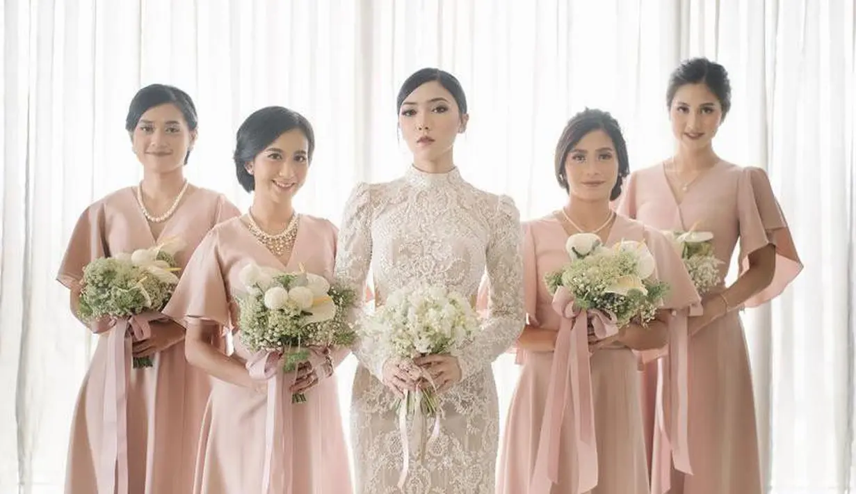 Sementara Isyana Sarasvati mengenakan kebaya brokat modern warna putih, para bridesmaids tampil anggun berbalut dress model v-neck warna pink muda. (Instagram/isyanasarasvati).