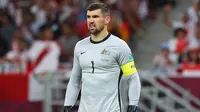 Mathew Ryan. Kiper Australia berusia 30 tahun yang baru bergabung dengan FC Copenhagen di awal musim 2022/2023 ini menjadi pemain aktif dengan penampilan terbanyak bagi Tim Socceroos dengan mengoleksi 75 caps sejak melakukan debut pada 5 Desember 2012. Piala Dunia 2022 Qatar akan menjadi Piala Dunia ketiganya, setelah selalu tampil dalam 2 edisi sebelumnya, 2014 dan 2018. Dari kedua edisi tersebut ia selalu tampil dalam 6 laga Timnas Australia yang selalu tersingkir di fase grup. (AFP/Karim Jaafar)