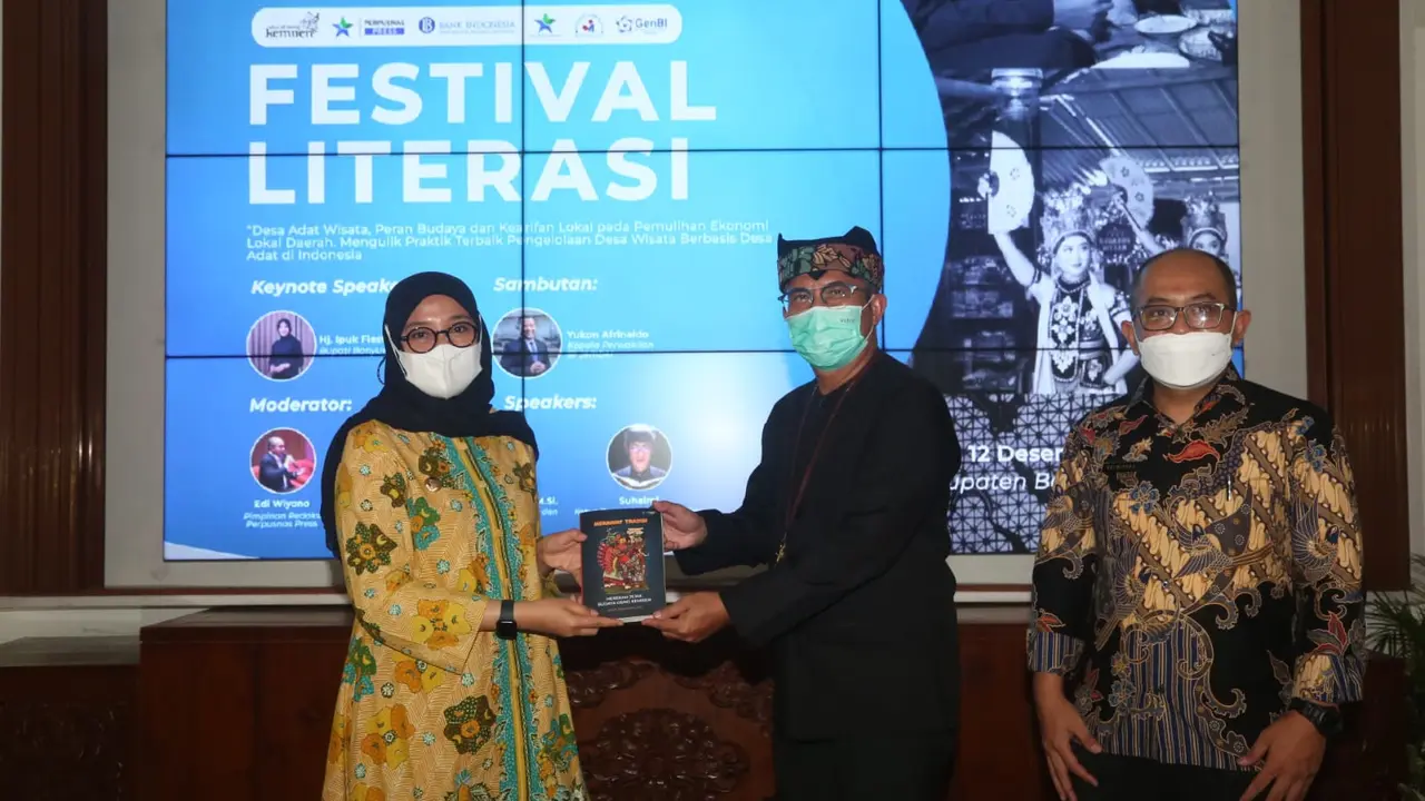 Kepala Kantor Perwakilan Bank Indonesia Jember Yukon Afrinaldo (kanan) menyerahkan buku "Jejak Budaya Osing Kemiren" kepada Bupati Banyuwangi Ipuk Fiestiandani. (Istimewa)