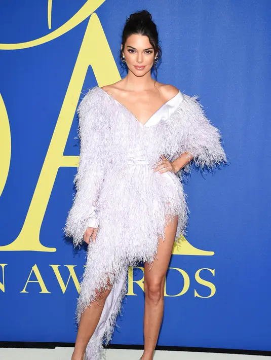 Model Kendall Jenner berpose saat menghadiri CFDA Fashion Awards 2018 di Museum Brooklyn di New York City, AS (4/6). Model 22 tahun ini tampil cantik dengan balutan gaun cocktail pink berbulu dan rambut berponi. (AP Photo/Evan Agostini)