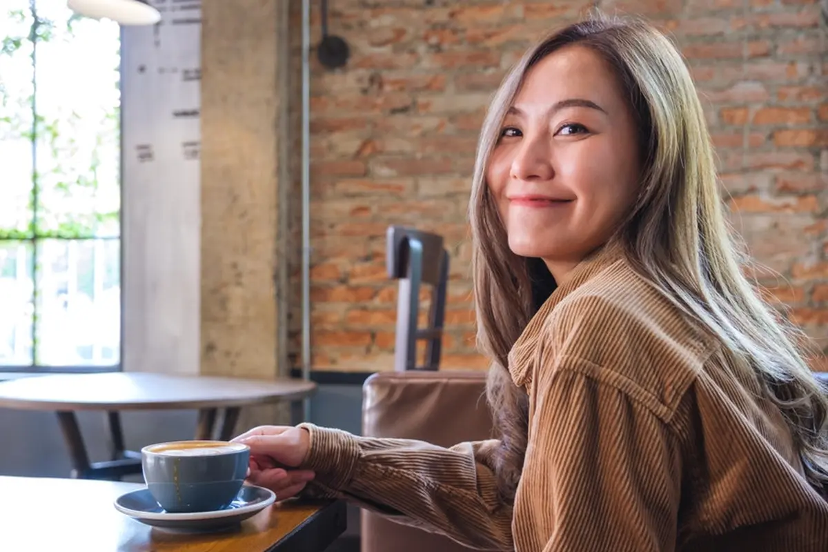 tenang kalem dewasa minum kopi di kafe baju coklat
