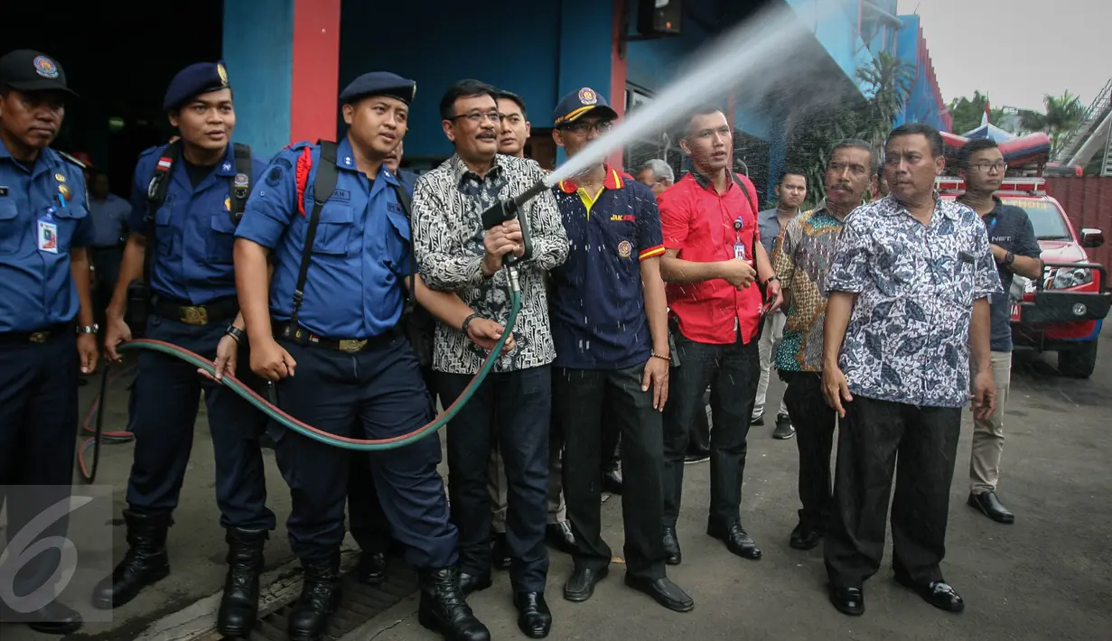 Wagub DKI Djarot Saiful Hidayat mencoba semprotan pemadam ketika mengunjungi Kantor Dinas Pemadam Kebakaran di Jalan KH Zainul Airifin, Jakarta, Sabtu (8/10). Djarot memantau kesiapan anggota dan peralatan pemadam kebakaran (Liputan6.com/Faizal Fanani)
