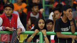 Suporter Persija termangu usai menyaksikan timnya berlaga melawan Madura United FC pada lanjutan Liga 1 di Stadion Patriot Candrabhaga, Bekasi, Kamis (4/5). Persija kalah 0-1. (Liputan6.com/Helmi Fithriansyah)
