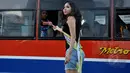 Warga yang berada di dalam bus juga mendapat uang dari para wanita cantik di Bundaran HI, Jakarta, Kamis (9/4/2015).  Kegiatan tersebut dalam rangka sosialisasi peluncuran sebuah aplikasi game online (Liputan6.com/Johan Tallo).