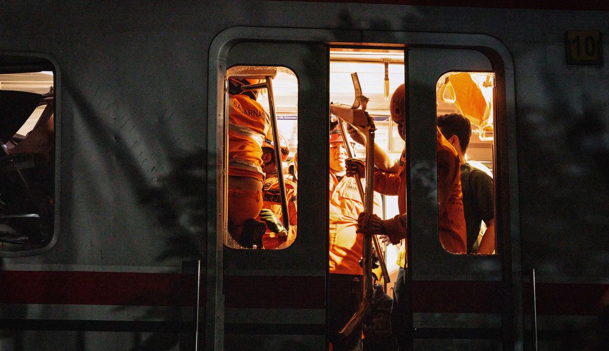 Tim penyelamat bekerja di lokasi terjadinya tabrakan kecelakaan Kereta Api Jarak Jauh (KAJJ) Argo Bromo Anggrek dengan Kereta Rel Listrik (KRL) Commuter Line di Stasiun Bekasi Timur, Jawa Barat, pada Selasa 28 April 2026 dini hari. (Yasuyoshi Chiba/AFP)