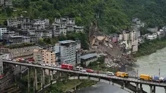 Kendaraan penyelamat bersiaga di jembatan saat tim penyelamat melakukan operasi pencarian dan penyelamatan di lokasi tanah longsor di Kabupaten Pengshui, Chongqing, Tiongkok barat daya, Sabtu, 18 Juli 2026. (AP Photo/Andy Wong)