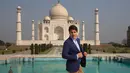 Perdana Meneteri (PM) Kanada Justin Trudeau merapikan jasnya sebelum berpose di depan Taj Mahal di sela-sela kunjungan ke India, Minggu (18/2). PM Kanada mengunjungi Taj Mahal bersama istri dan anak-anaknya. (AP/Manish Swarup)