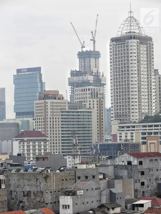 Pemandangan pemukiman padat penduduk dengan latar gedung bertingkat di Jakarta Pusat, Kamis (31/1). Populasi penduduk Jakarta yang mencapai 35,6 juta jiwa diperkirakan akan bertambah 4,1 juta orang antara 2017-2030. (Liputan6.com/Faizal Fanani)