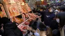 Orang-orang membeli makanan dan perlengkapan untuk merayakan Tahun Baru di distrik perbelanjaan Ueno di Tokyo, Selasa (29/12/2020). Tokyo melaporkan peningkatan kasus virus corona menjelang musim libur tahun baru, dimana biasanya masyarakat yang tinggal di ibu kota akan mudik. (Kazuhiro NOGI/AFP)