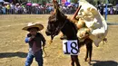 Seorang anak membawa keledainya yang dihias saat mengikuti National Donkey Fair di Otumba, Meksiko (1/5). Acara tahunan ini diikuti sekitar 7.000 orang. (AFP Photo/Pedro Pardo)