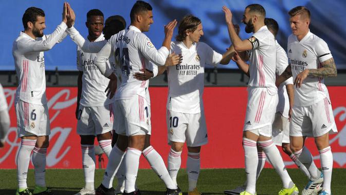 Para pemain Real Madrid merayakan gol yang dicetak oleh Karim Benzema ke gawang Valencia pada laga Liga Spanyol di Stadion Alfredo Di Stefano, Minggu (14/2/2021). Real Madrid menang dengan skor 2-0. (AP/Manu Fernandez)