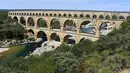 Pemandangan Pont du Gard atau Jembatan Gard di Vers-Pont-du-Gard, Prancis, Rabu (21/8/2019). Karena kemegahannya, jembatan ini mendapat gelar sebagai peninggalan bersejarah dunia oleh UNESCO. (Pascal GUYOT/AFP)