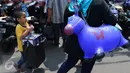 Seorang anak membawa kantong plastik berisi mainan yang dibelinya di Pasar Gembrong, Jakarta, Jumat (8/7). Libur lebaran banyak dimanfaatkan orang tua untuk mengajak anaknya berbelanja aneka mainan murah. (Liputan6.com/Angga Yuniar)
