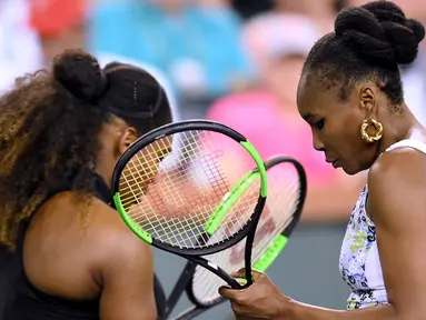 Venus Williams (kanan) saat pertandingan melawan adiknya Serena Williams dalam turnamen BNP Paribas Open di Indian Wells Tennis Garden, California (12/3). (Harry How / Getty Images / AFP)