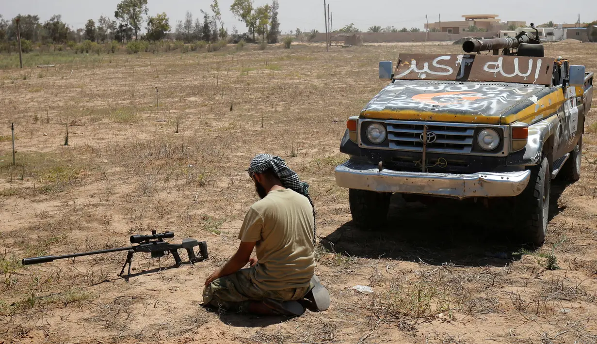Pasukan tentara Libya melaksanakan salat disela-sela pertempuran sengit melawan militan ISIS untuk merebut kembali kota Sirte, Libya, (21/7). Dengan kondisi seadanya, mereka tak meninggalkan rukun Islam kedua itu. (REUTERS/Ismail Zitouni)