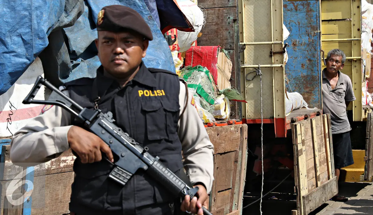 Petugas berjaga dibelakang truk penyelundupan barang asal impor melalui jalur interseluler di Polres Pelabuhan Tanjung Priok, Jakarta, Senin (23/11). Polres Pelabuhan berhasil mengamankan 298 koli muatan dari KM UMSINI. (Liputan6.com/Immanuel Antonius)