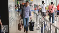 Seorang calon penumpang bersiap masuk ke dalam Bandara Halim Perdanakusuma Jakarta, Senin (4/7). H-2 jelang Idul Fitri 1437 H, ribuan calon penumpang diberangkatkan dari Bandara Halim Perdanakusuma. (Liputan6.com/Helmi Fithriansyah)