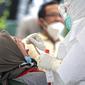 Warga menjalani tes usap PCR COVID-19 di Puskesmas Kecamatan Duren Sawit, Jakarta, Kamis (22/7/2021). Peningkatan testing dan tracing di wilayah padat penduduk diharapkan bisa mempercepat upaya memutus mata rantai penyebaran COVID-19. (Liputan6.com/Faizal Fanani)