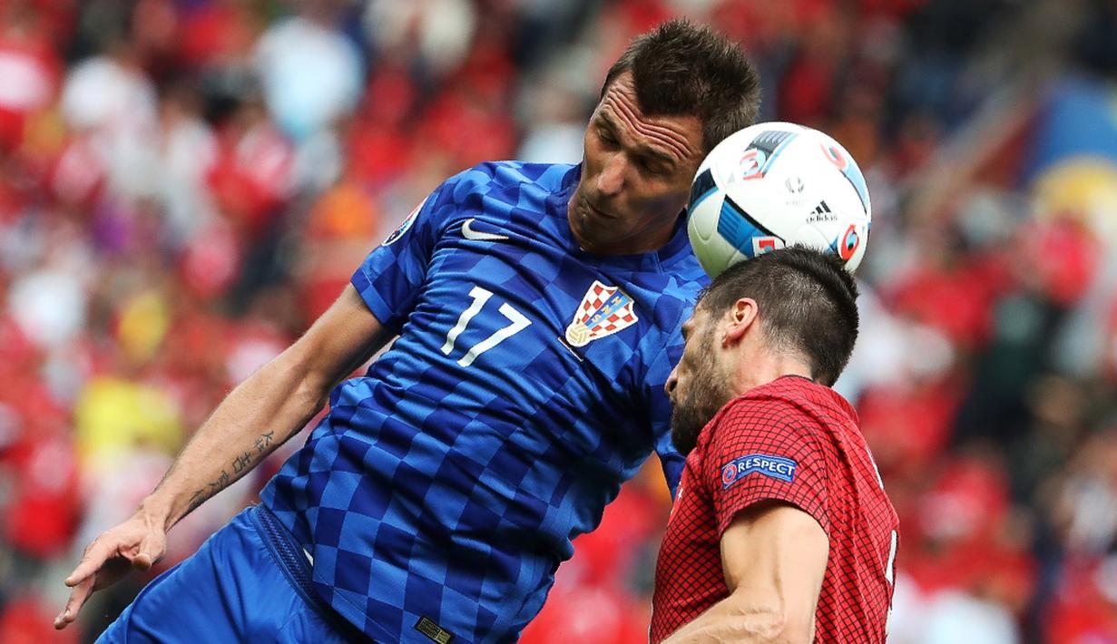 Striker Kroasia, Mario Mandzukic, duel dengan pemain Turki, Cenk Tosun, dalam laga Grup D Piala 2016 di Stadion Parc des Princes, Paris, (12/6/2016). (AFP/Kenzo Tribouillard)
