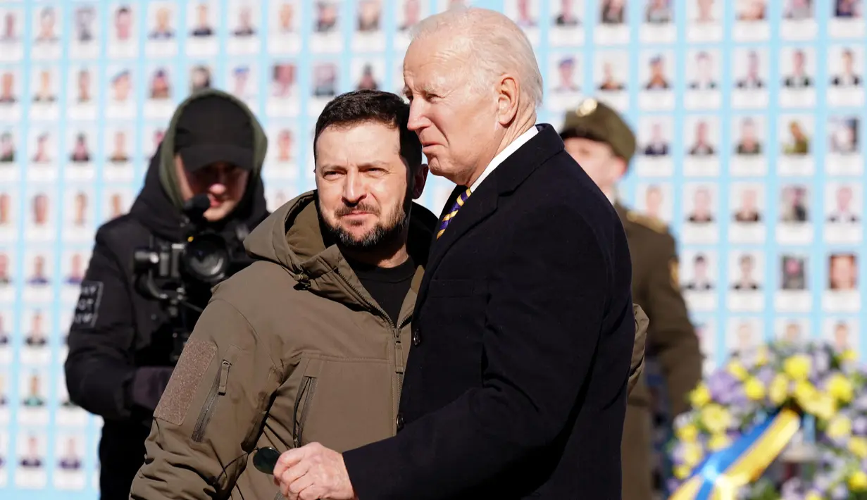 Presiden AS Joe Biden (kanan) disambut oleh Presiden Ukraina Volodymyr Zelensky (kiri) saat berkunjung di Kyiv, Ukraina pada 20 Februari 2023. Kunjungan Biden dilakukan jelang peringatan satu tahun invasi Rusia. Ia menyatakan bahwa dukungan Washington ke Kyiv tak tergoyahkan dan mengumumkan lebih banyak bantuan untuk Ukraina. (Dimitar DILKOFF/AFP)