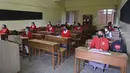 Suasana kegiatan belajar mengajar di kelas saat sekolah dibuka kembali setelah ditutup hampir sembilan bulan karena pandemi COVID-19 di Ahmedabad, India, Senin (11/1/2021). Negara bagian Gujarat telah membuka kembali sekolah hanya untuk kelas 10 dan 12. (Sam PANTHAKY / AFP)