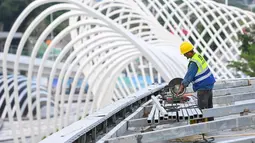 Seorang staf bekerja di lokasi pembangunan sebuah kincir ria di taman budaya pesisir Baoan di Shenzhen, Provinsi Guangdong, China selatan (6/10/2020). Kincir ria setinggi 128 meter tersebut saat ini sedang dalam tahap pembangunan. (Xinhua/Liu Dawei)