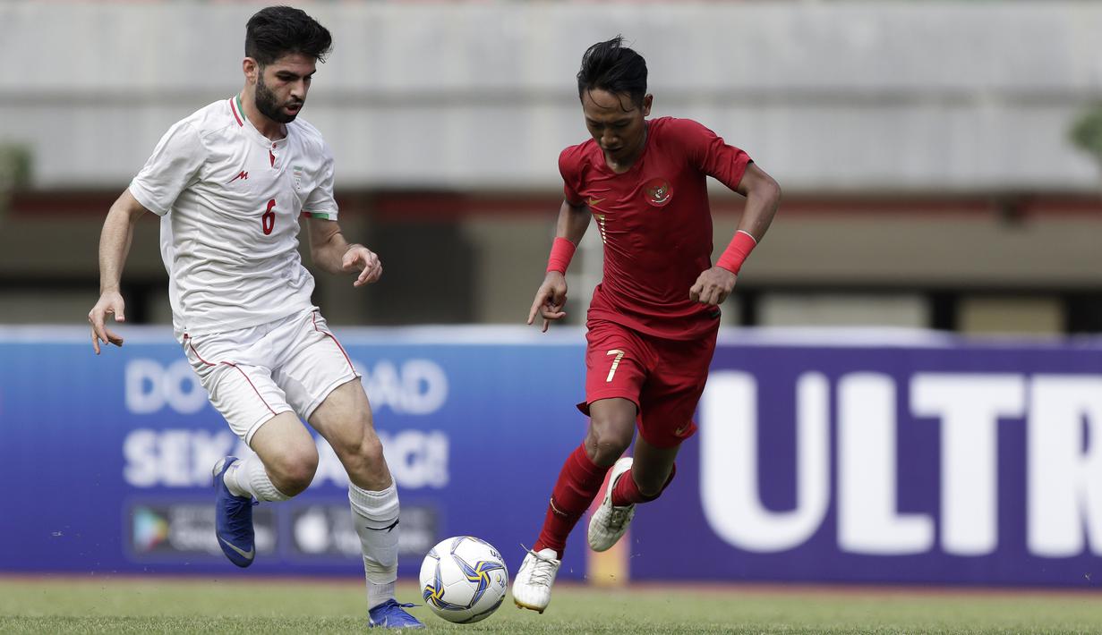 Gelandang Timnas Indonesua U-19, Beckham Putra, berebut bola dengan pemain Timnas Iran U-19 pada laga uji coba di Stadion Patriot Chandrabhaga, Bekasi, Sabtu (7/9). Indonesia kalah 2-4 atas Iran. (Bola.com/Yoppy Renato)