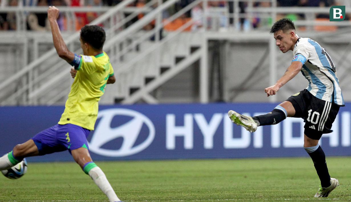 <p>Pemain Timnas Argentina U-17, Claudio Echeverri (kanan),&nbsp;menendang bola yang membuahkan gol ke gawang Brasil U-17 dalam pertandingan perempat final Piala Dunia U-17 2023 yang berlangsung di Jakarta International Stadium, Jumat (24/11/2023). (Bola.com/Arief Bagus)</p>