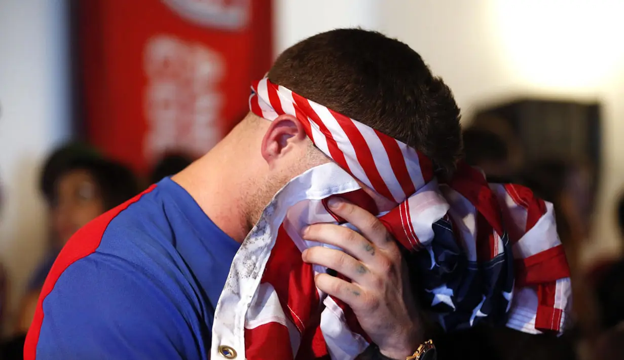 Salah satu pendukung Timnas Amerika Serikat menutupi wajahnya saat menyaksikan gol kedua Portugal yang dicetak Silvestre Varela di Los Angeles, Kalifornia, (22/6/2014). (REUTERS/Lucy Nicholson) 