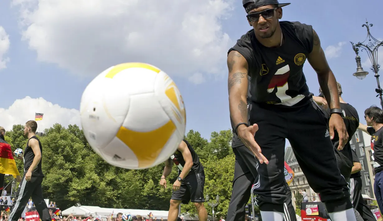 Pemain Timnas Jerman, Jerome Boateng, melemparkan bola ke arah para suporter yang ikut merayakan kemenangan Der Panzer, Berlin, (15/7/2014). (REUTERS/Axel Schmidt)