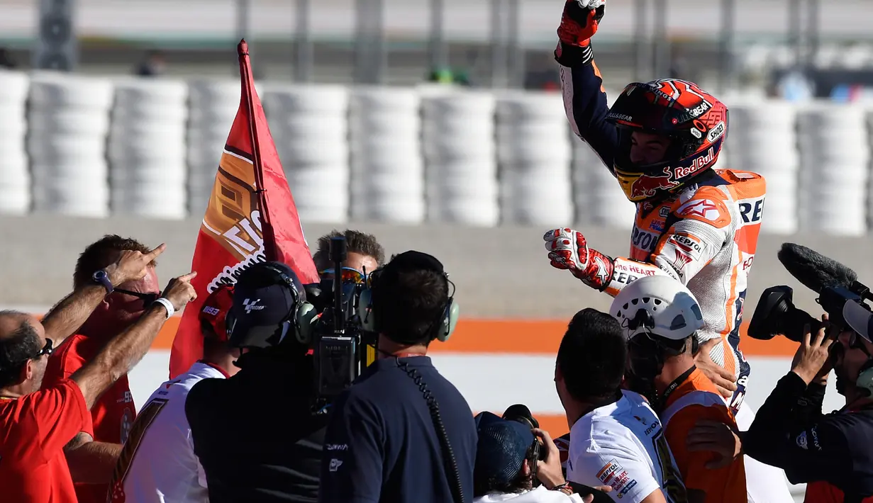 Pembalap Spanyol Repsol Honda, Marc Marquez meluapkan kegembiraannya setelah memenangkan balapan seri ke 18 MotoGP Grand Prix Valencia di Sirkuit Ricardo Tormo, Valencia (12/11). Pemenang MotoGP Valencia yakni Dani Pedrosa. (AFP PHOTO / Jose Jordan)