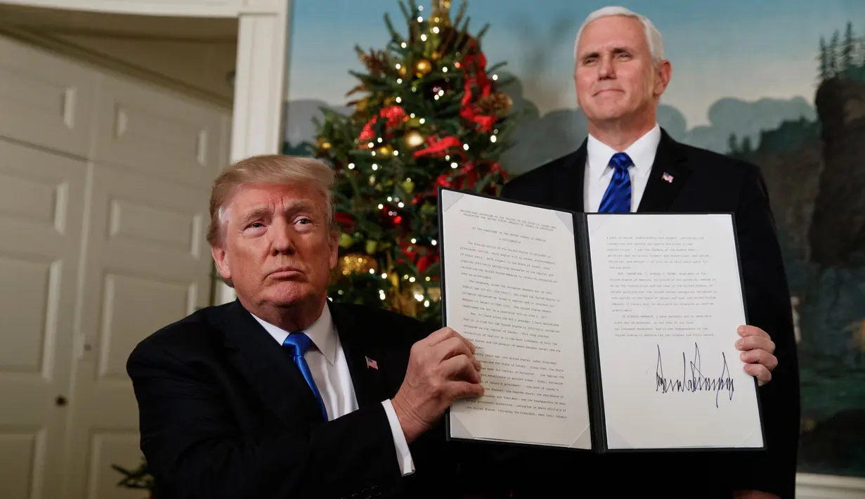 Presiden AS Donald Trump menunjukkan dokumen pengumuman Yerusalem sebagai ibukota Israel yang telah ditandatangani di Ruang Penerimaan Diplomatik Gedung Putih, Washington, Rabu (6/12). (AP Photo / Evan Vucci)