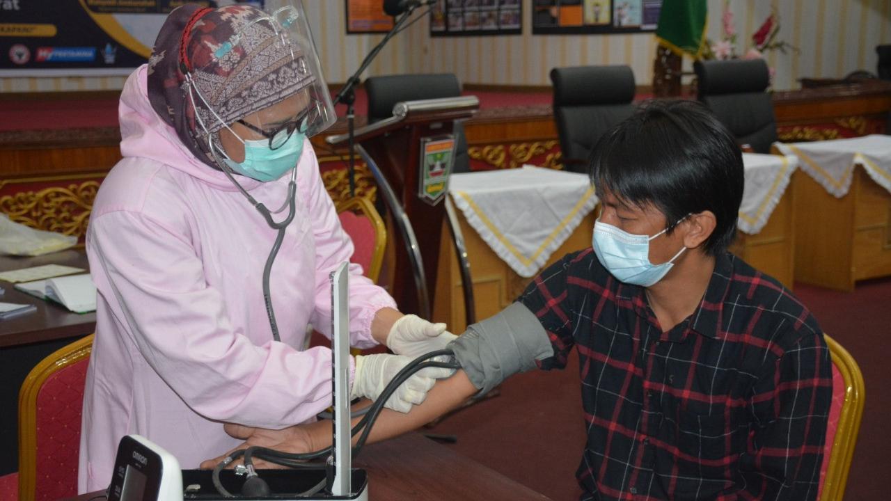 Ketua IJTI Sumbar, John Nedy Kambang melakukan cek kesehatan sebelum vaksinasi Covid-19. (Liputan6.com/ Humas Pemprov Sumbar).