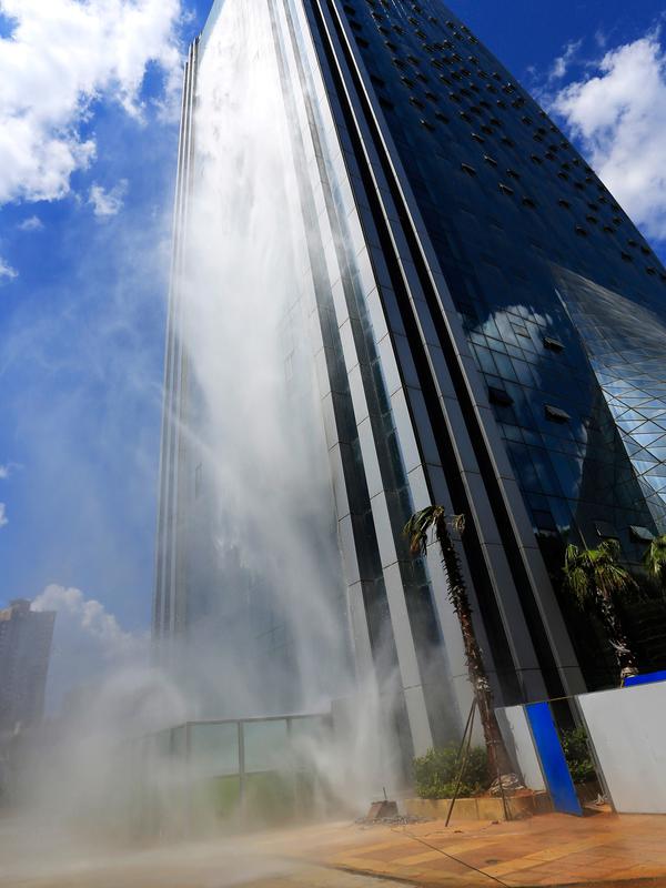 Air terjun buatan di sisi gedung pencakar langit Liebian International Plaza di Kota Guiyang, China, 20 Juli 2018. Air terjun buatan ini menggunakan air hujan dan air tanah yang dikumpulkan dalam tangki bawah tanah berukuran raksasa. (AFP/China OUT)